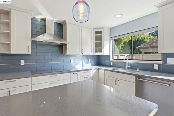 a kitchen with stainless steel appliances a sink a stove and cabinets