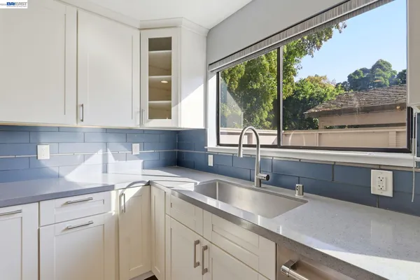 a kitchen with stainless steel appliances granite countertop a sink and a white cabinets