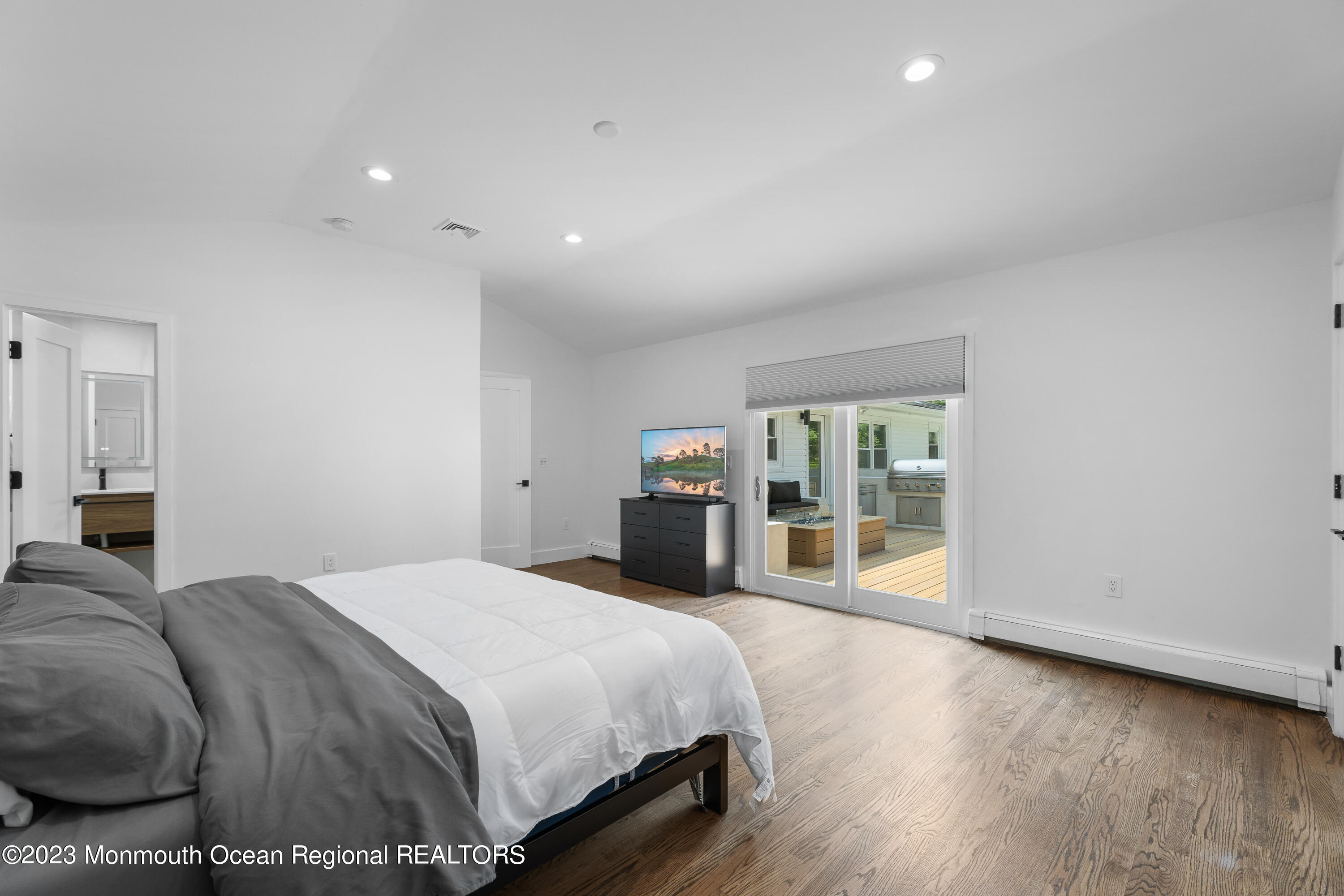 186 Delaware Avenue, Unit WINTER Oakhurst, NJ 07755 - Photo 6 of 31 a bedroom with a bed and wooden floor