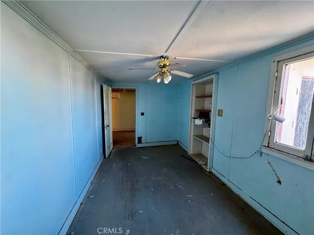 en empty room with windows and fan