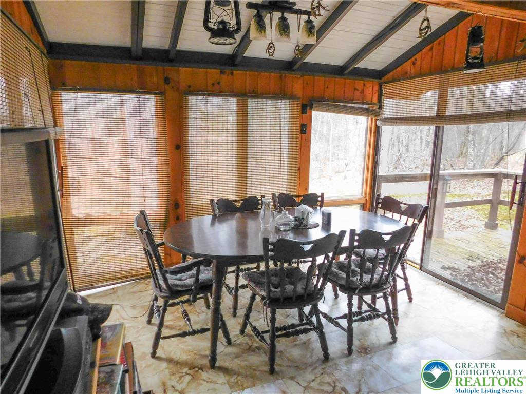 156 Pine Flats Colony Road Dingmans Ferry, PA 18328 - Photo 7 of 16 a view of a dining room with furniture large windows and wooden floor