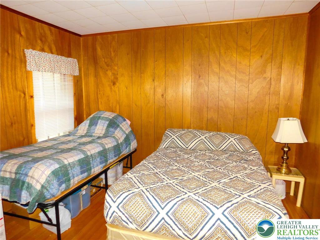 156 Pine Flats Colony Road Dingmans Ferry, PA 18328 - Photo 9 of 16 a bedroom with a bed and a lamp