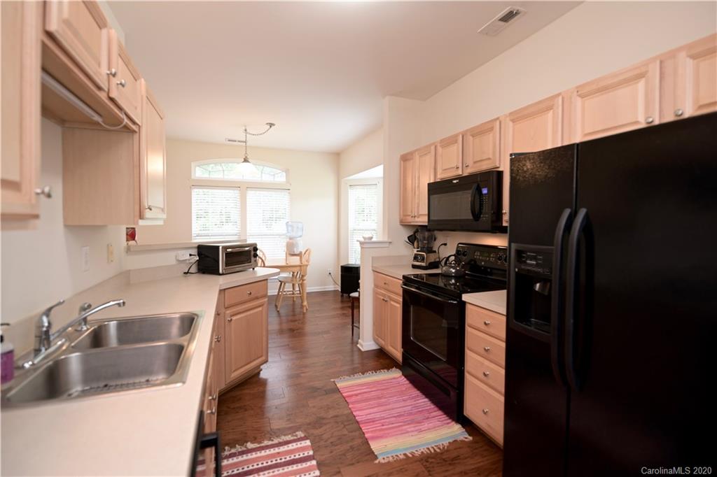 6152 Prosperity Church Road Charlotte, NC 28269 - Photo 13 of 33 a kitchen with stainless steel appliances a refrigerator a sink a stove a counter space and cabinets