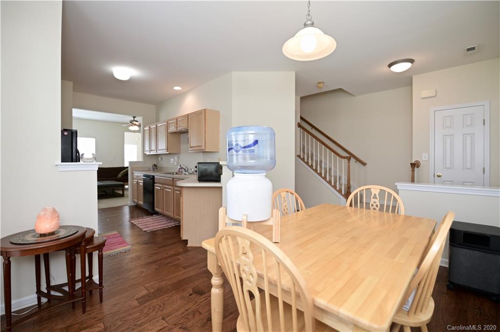 6152 Prosperity Church Road Charlotte, NC 28269 - Photo 9 of 33 a kitchen with kitchen island a stove a table and chairs in it