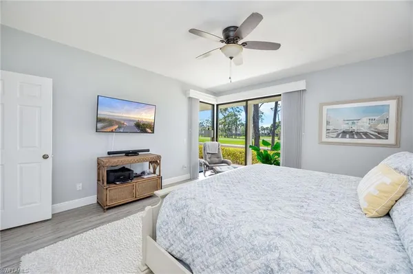 a bedroom with a bed a large window with table and chairs