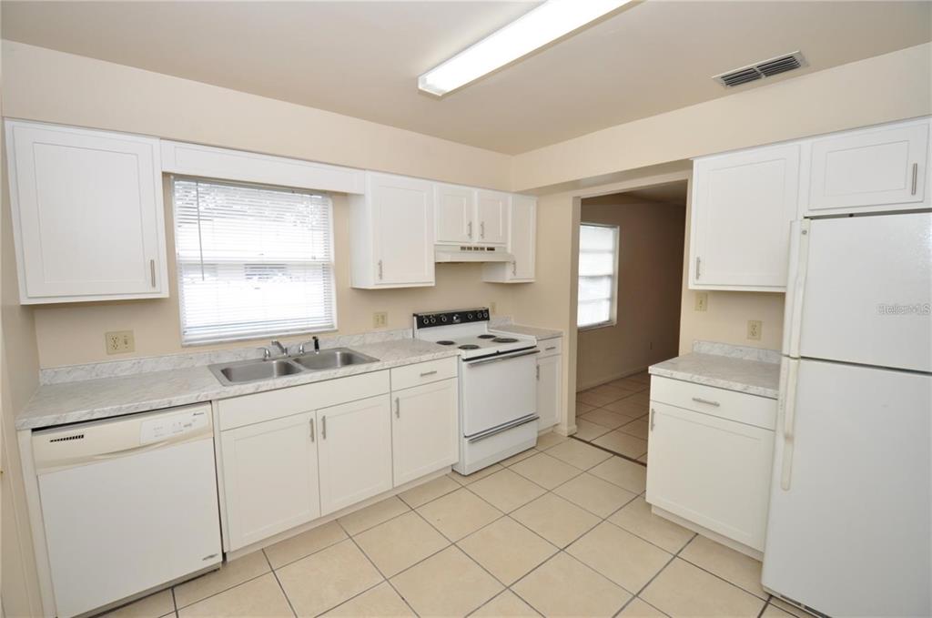 1434 East Fern Road, Unit 1434 Lakeland, FL 33801 - Photo 5 of 13 a kitchen with white cabinets and white appliances