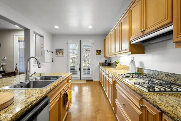 a kitchen with kitchen island stainless steel appliances a sink stove and cabinets