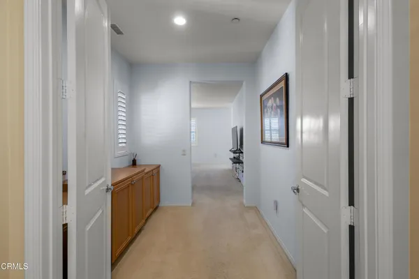 a view of a hallway with wooden cabinets