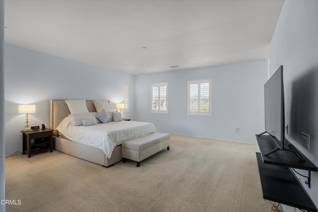 1365 Donegal Way Oxnard, CA 93035 - Photo 27 of 34 a spacious bedroom with a bed and a flat tv screen on a dresser