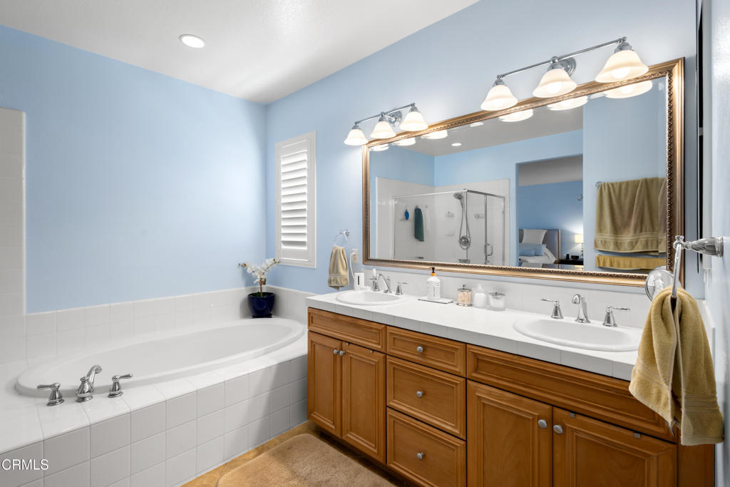 1365 Donegal Way Oxnard, CA 93035 - Photo 31 of 34 a bathroom with a tub a double vanity sink and a mirror