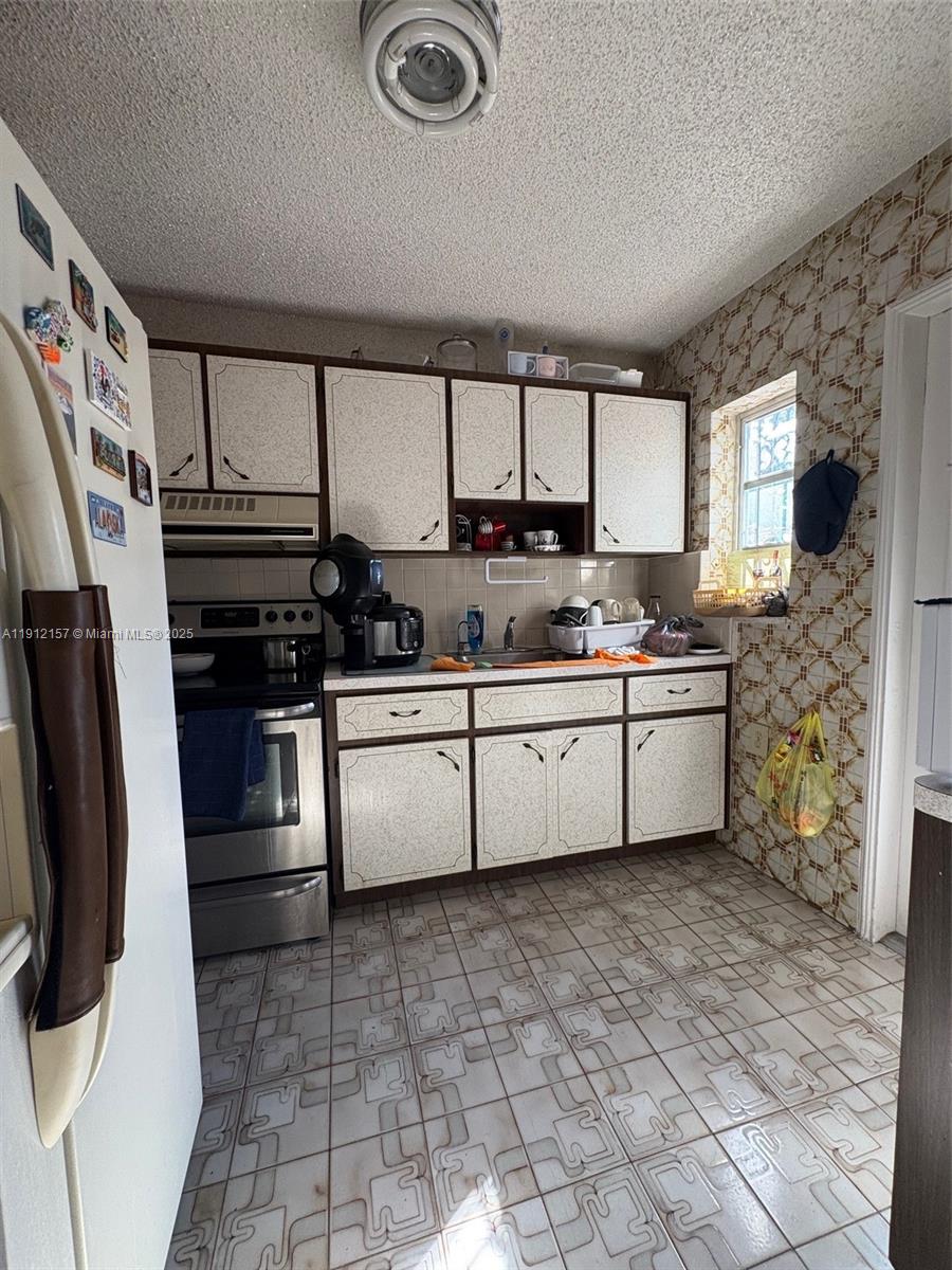 536 East 27th Street, Unit 536 Hialeah, FL 33013 - Photo 5 of 11 a kitchen with stainless steel appliances a stove a sink and a refrigerator