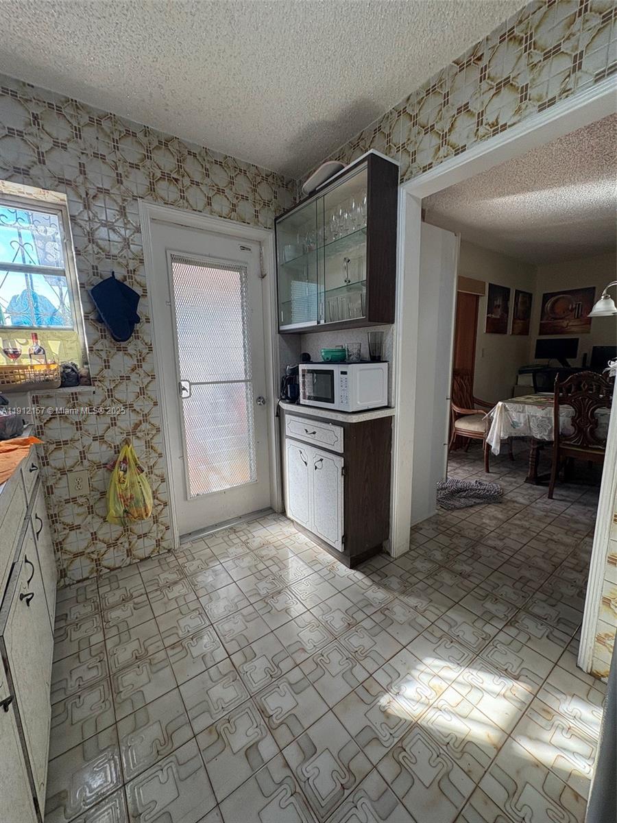 536 East 27th Street, Unit 536 Hialeah, FL 33013 - Photo 6 of 11 a kitchen with stainless steel appliances kitchen island granite countertop a refrigerator and a stove