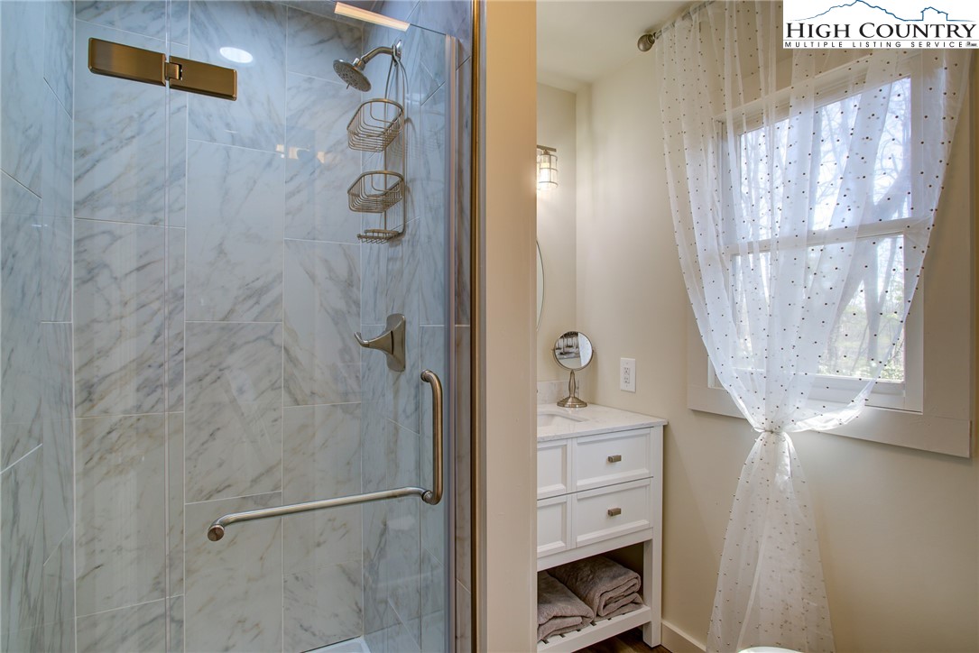 216 Ivy Road Newland, NC 28657 - Photo 11 of 26 a bathroom with a granite countertop shower a mirror and a sink