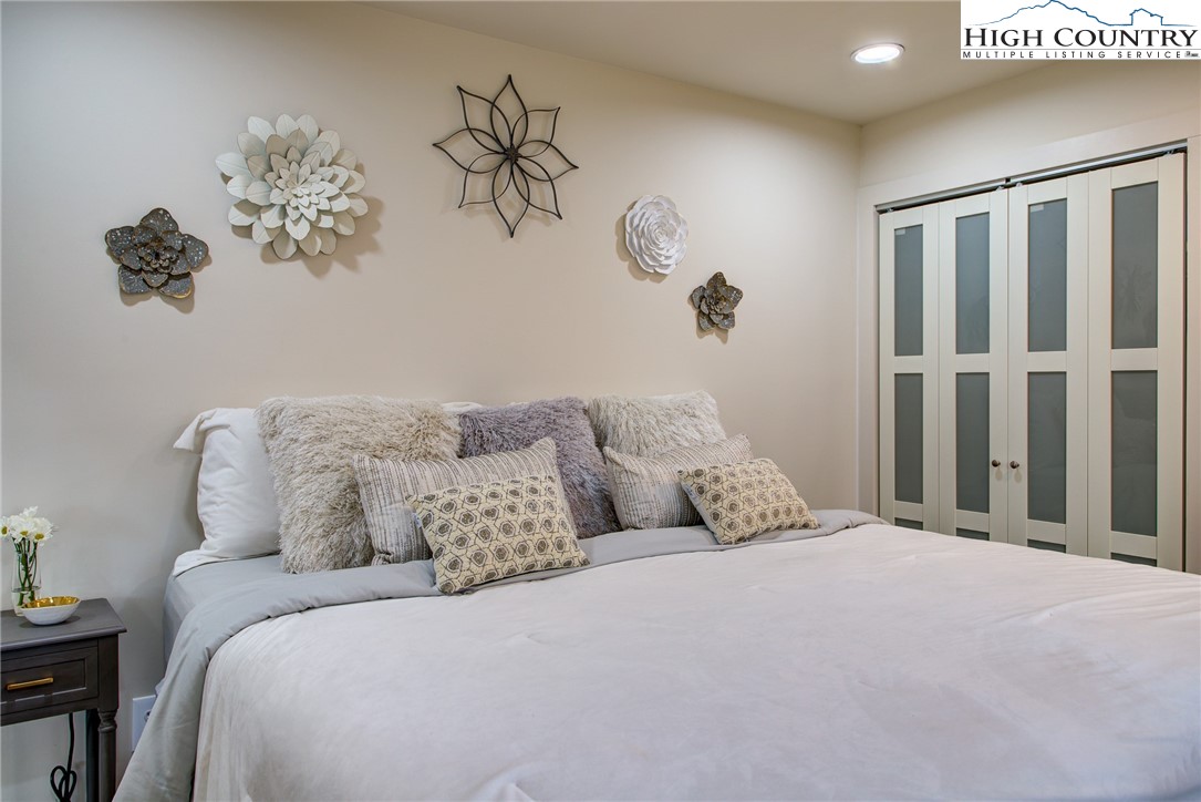 216 Ivy Road Newland, NC 28657 - Photo 9 of 26 a bedroom with a large bed and a chandelier
