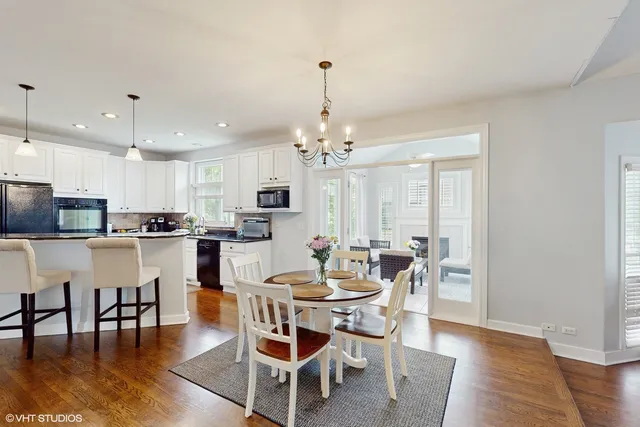 a view of a dining room and livingroom with furniture wooden floor a chandelier