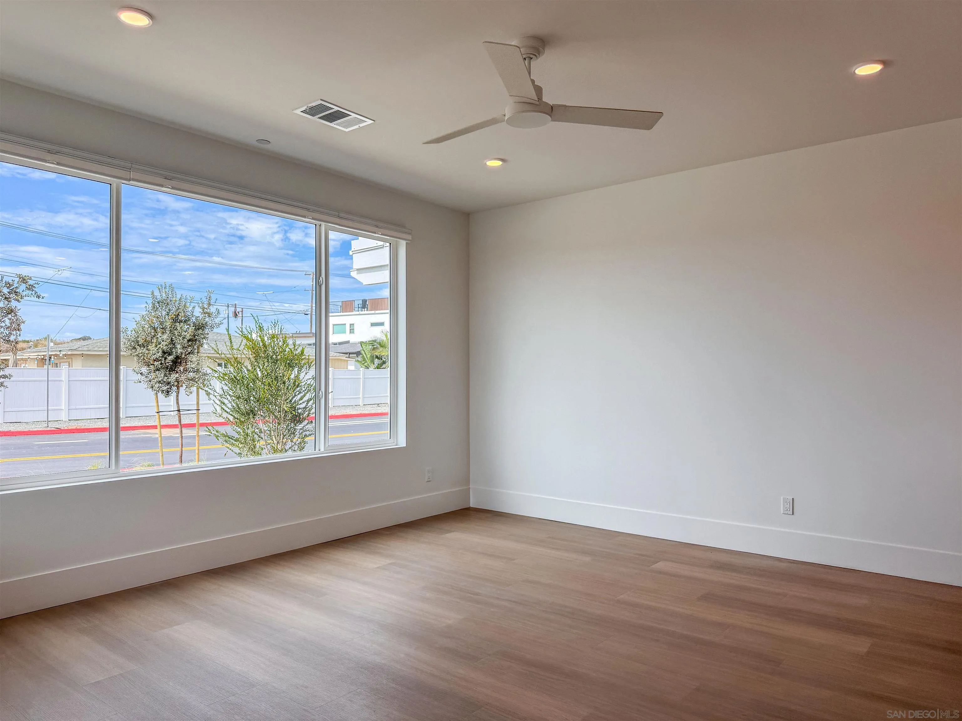 7290 Ponto Drive North, Unit 7302 Carlsbad, CA 92011 - Photo 11 of 55 an empty room with wooden floor and windows