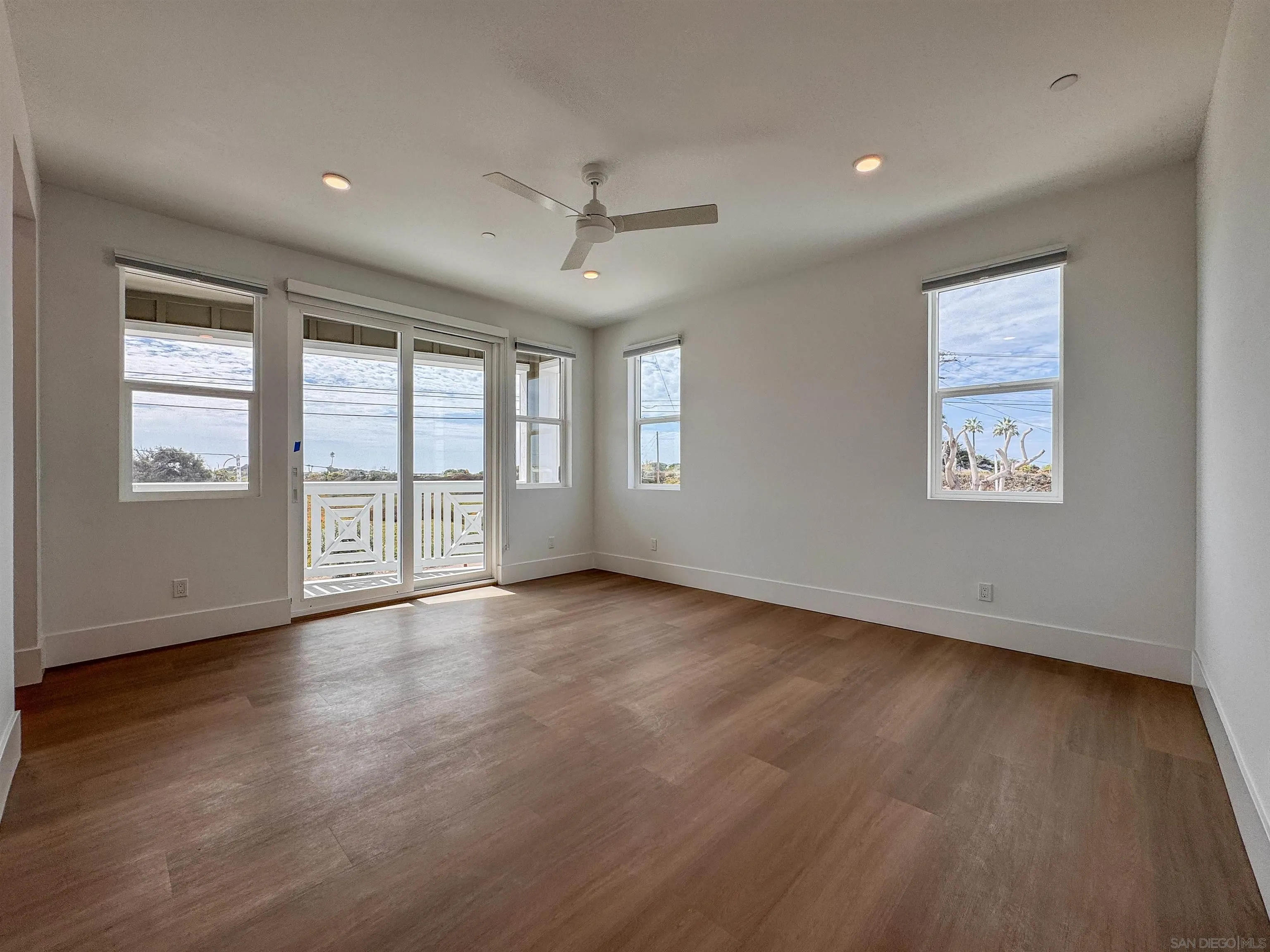 7290 Ponto Drive North, Unit 7302 Carlsbad, CA 92011 - Photo 18 of 55 a view of an empty room with wooden floor and a window