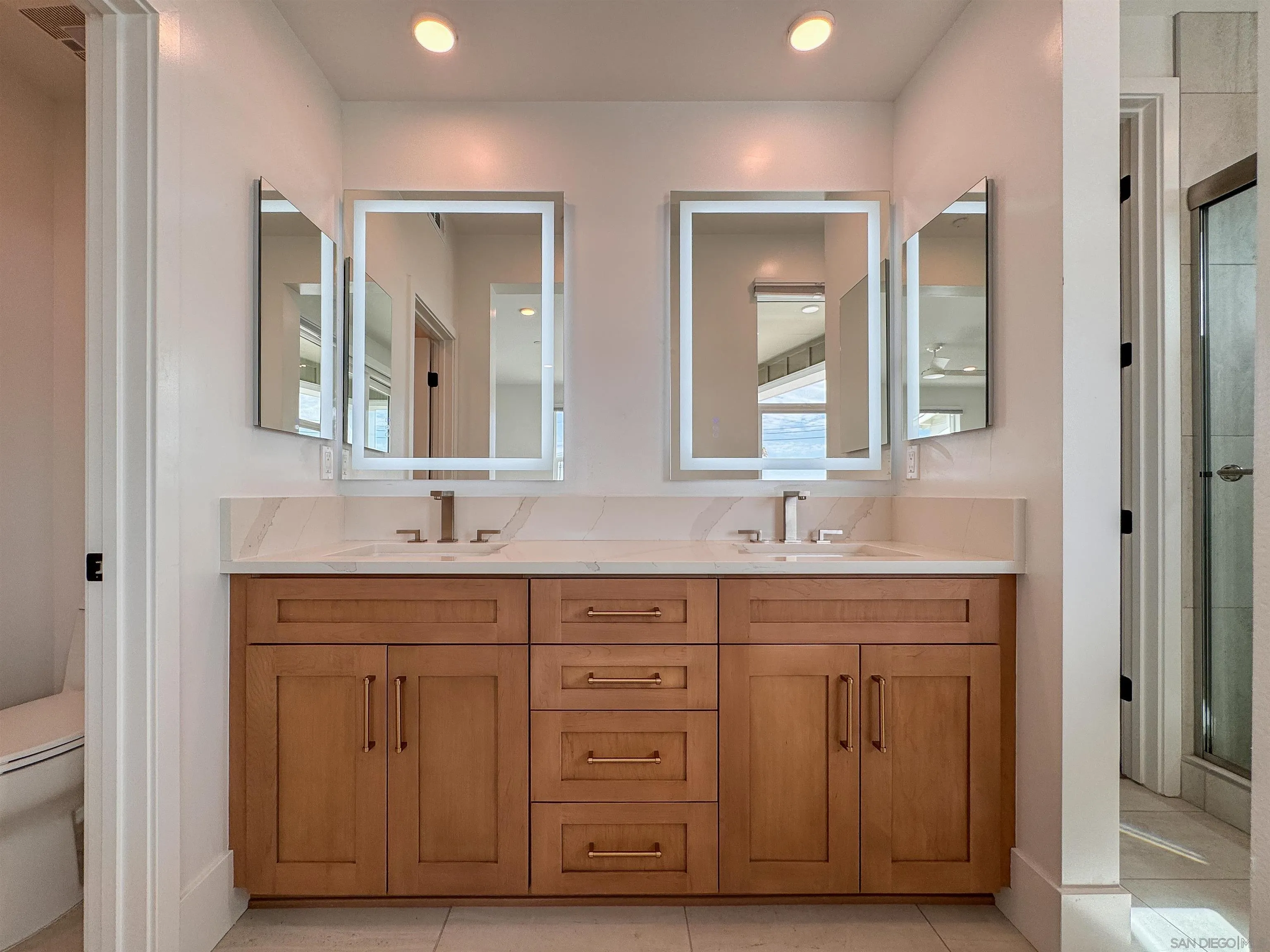 7290 Ponto Drive North, Unit 7302 Carlsbad, CA 92011 - Photo 19 of 55 a bathroom with double vanity sinks and a mirror