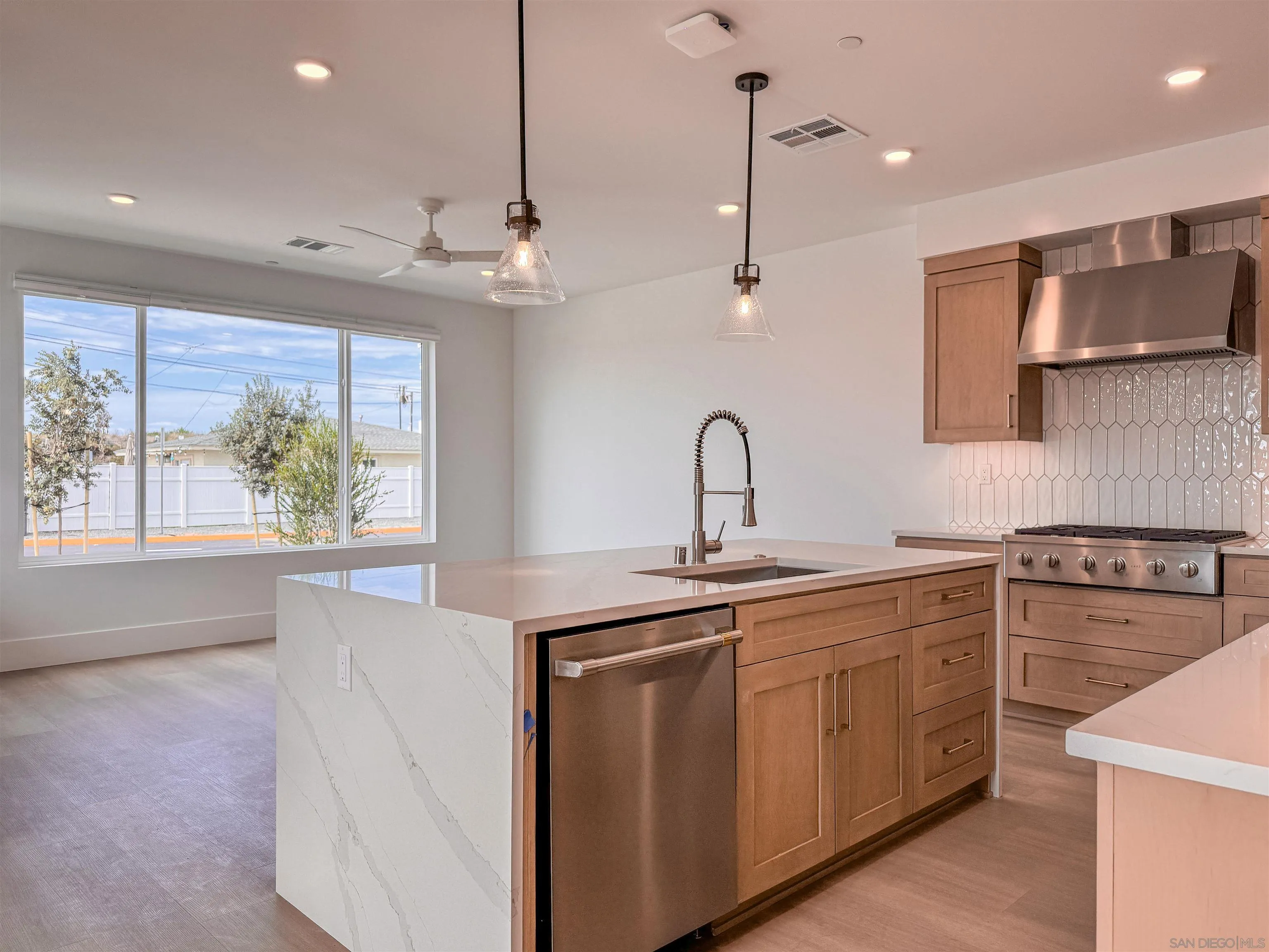 7290 Ponto Drive North, Unit 7302 Carlsbad, CA 92011 - Photo 2 of 55 a kitchen with kitchen island a sink stainless steel appliances and cabinets