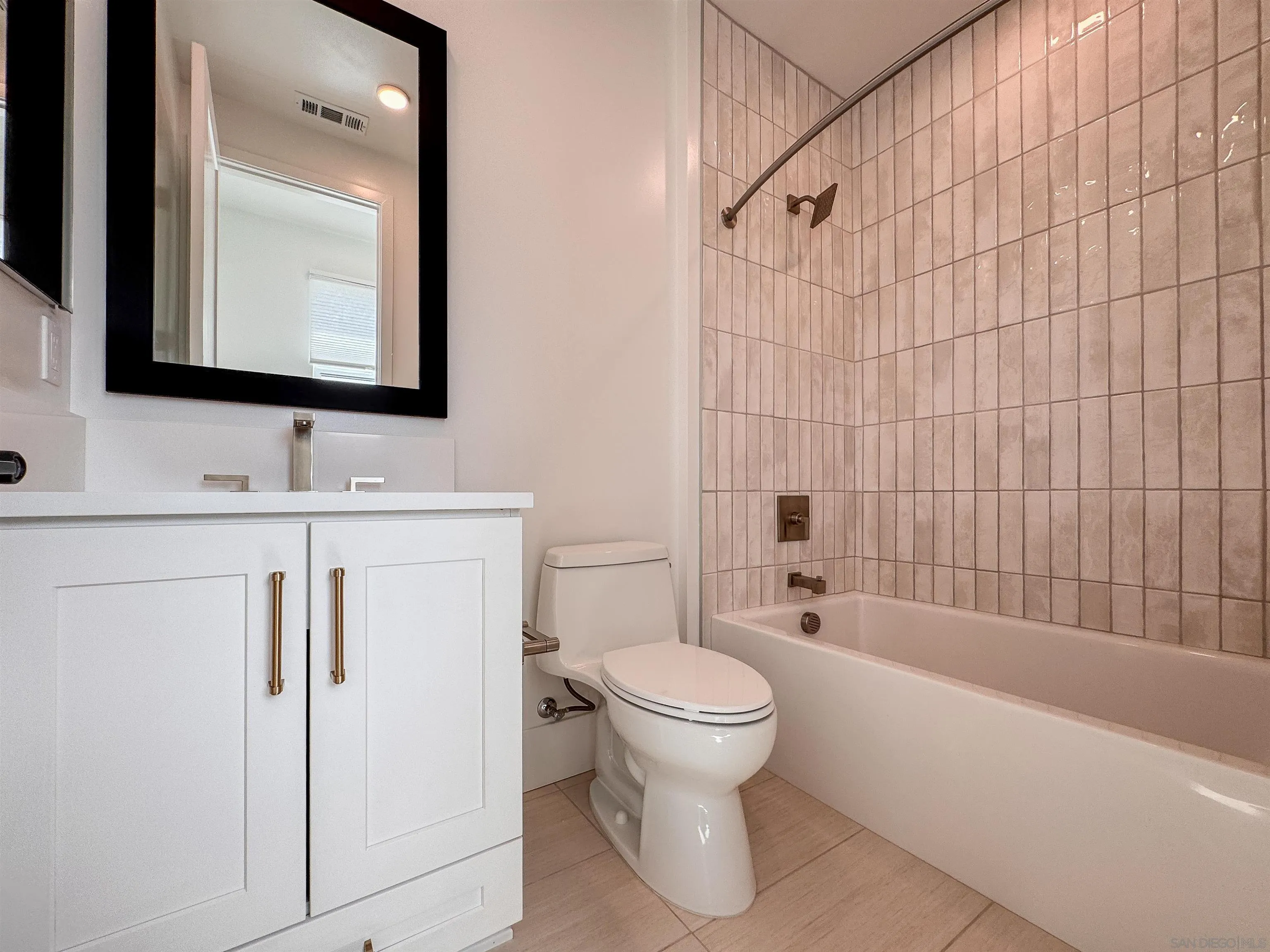 7290 Ponto Drive North, Unit 7302 Carlsbad, CA 92011 - Photo 25 of 55 a bathroom with a toilet sink vanity tub and mirror