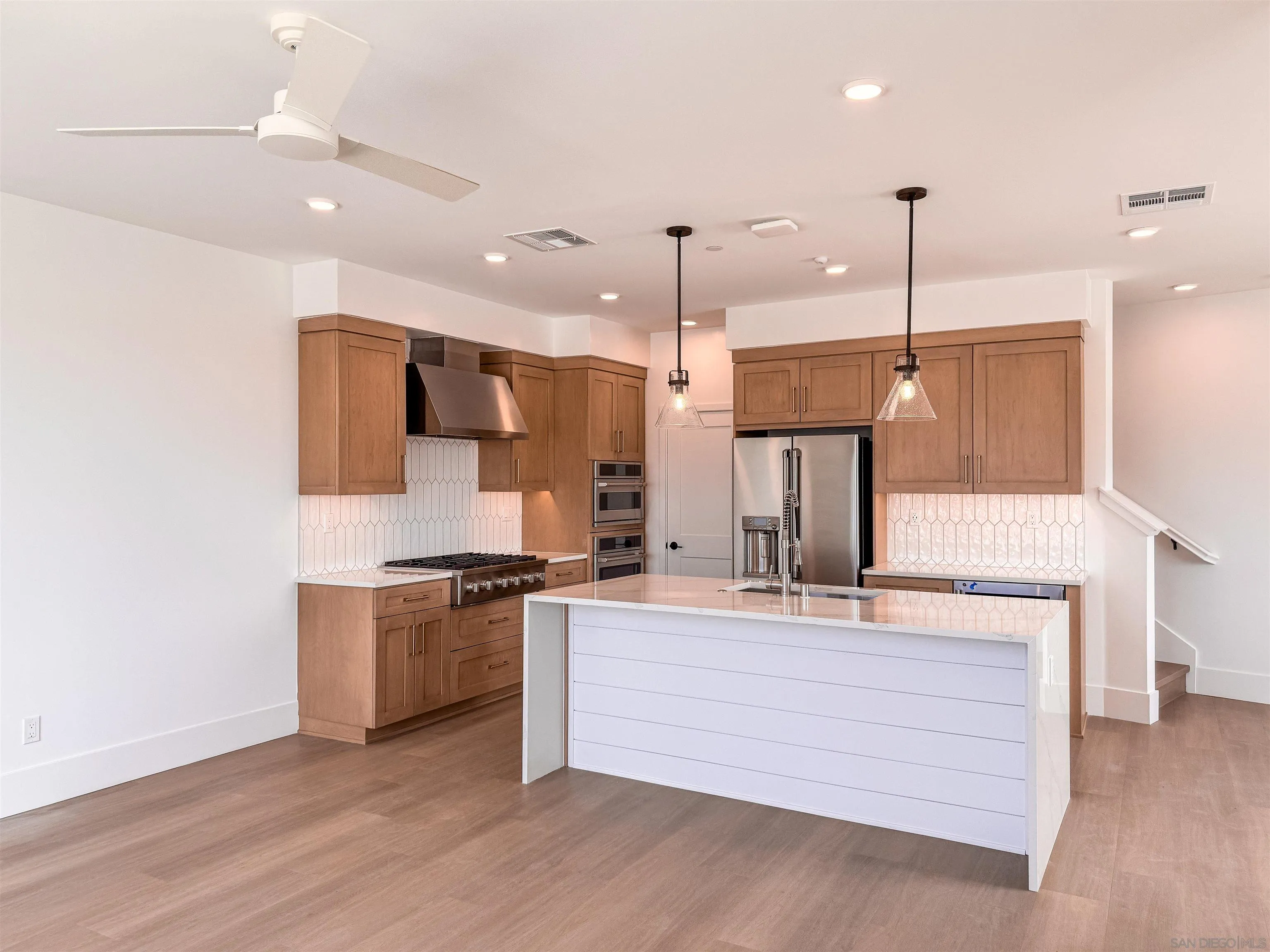 7290 Ponto Drive North, Unit 7302 Carlsbad, CA 92011 - Photo 10 of 55 a kitchen with stainless steel appliances granite countertop a sink a stove and a refrigerator