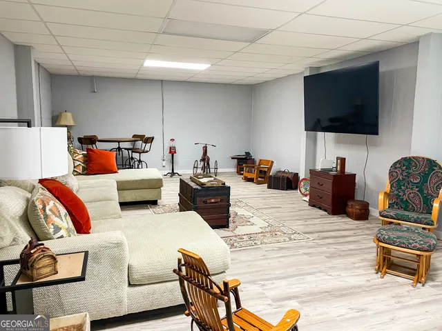 a kitchen with stainless steel appliances granite countertop a stove top oven a sink dishwasher a dining table and chairs with wooden floor