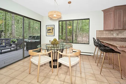 a dining room with furniture and large windows