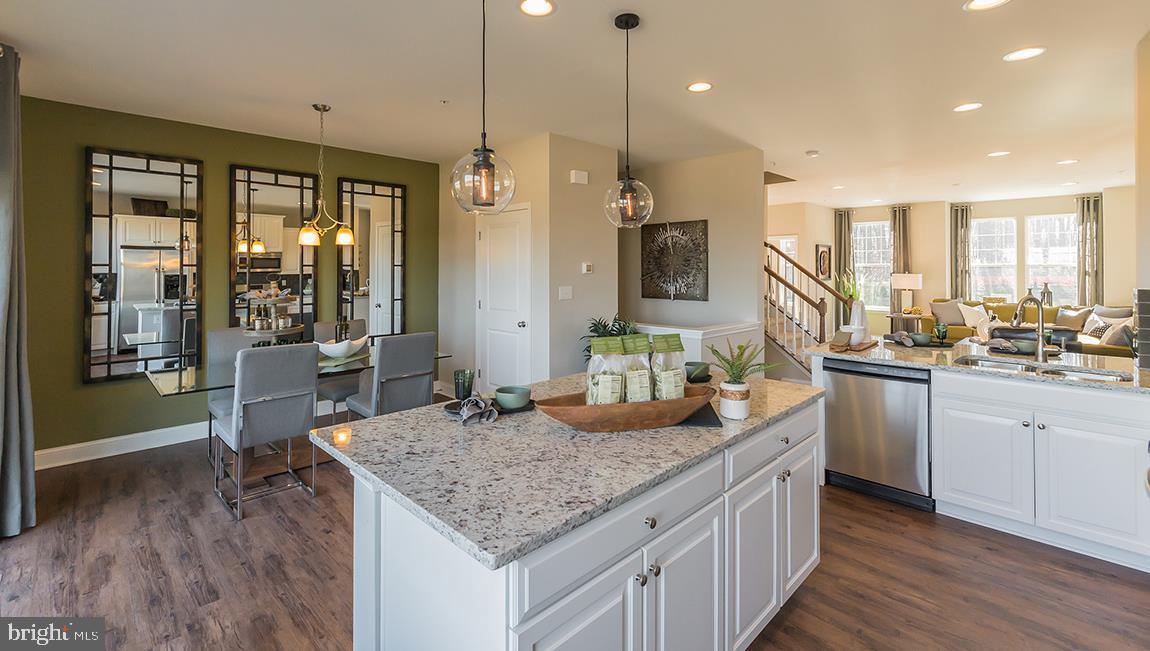a kitchen with granite countertop kitchen island wooden floor center island and stainless steel appliances