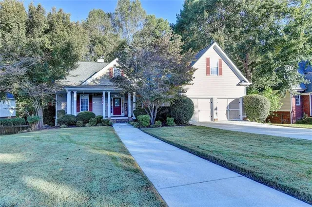 a front view of a house with a yard and trees