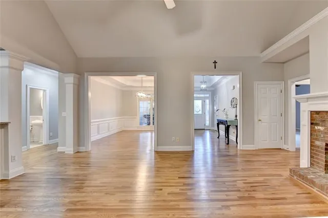 a large kitchen with stainless steel appliances granite countertop a stove top oven a sink dishwasher and a refrigerator with wooden floor