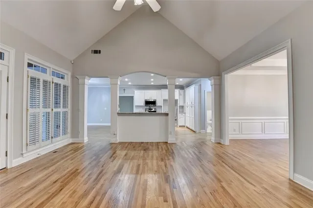 a view of empty room with wooden floor and fan