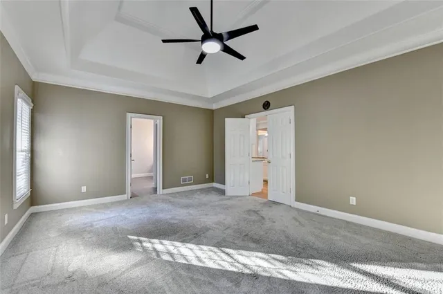 an empty room with a window and a fan