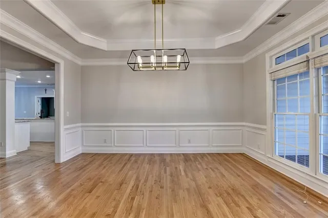 a view of a livingroom with wooden floor a fireplace a ceiling fan and front door