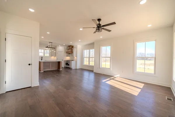 a view of an empty room with a window and wooden floor