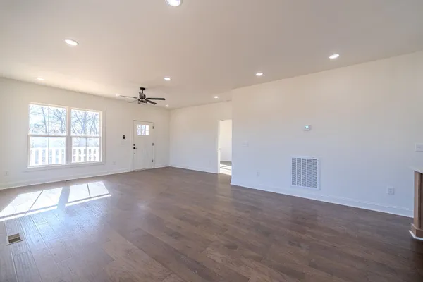 a view of hallway with a large window and a ceiling fan