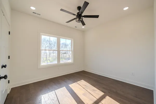 a view of a room with a ceiling fan wooden floor and window