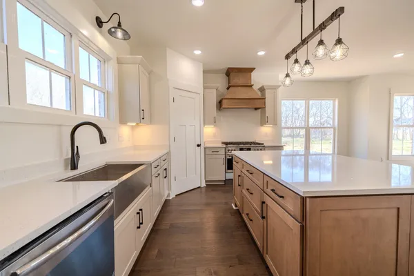 a kitchen with granite countertop cabinets stainless steel appliances and wooden floor