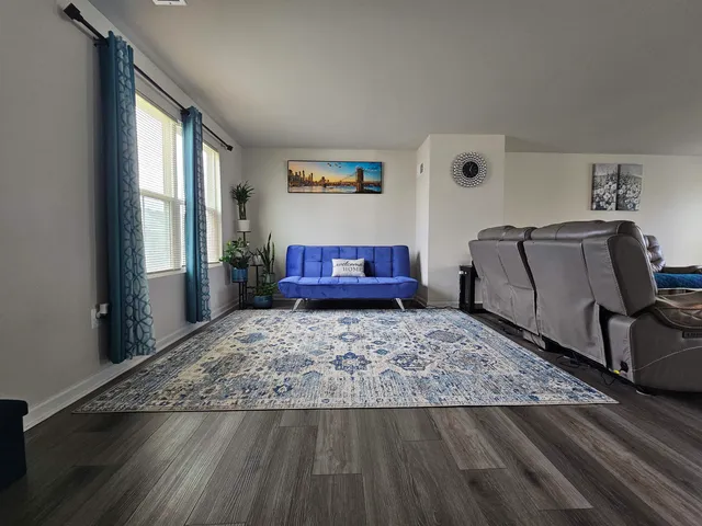 a living room with a couch and wooden floor