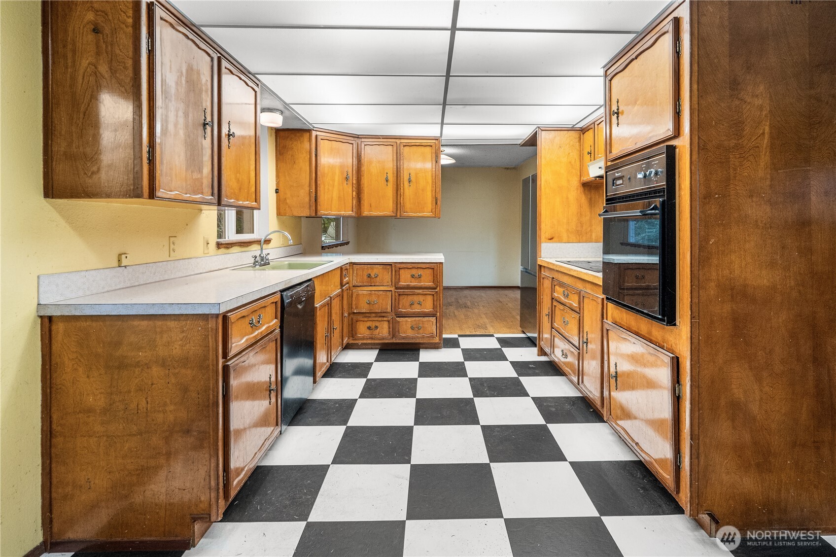 9139 Burnett Road Southeast Yelm, WA 98597 - Photo 11 of 40 a kitchen with a checkered floor and white cabinets