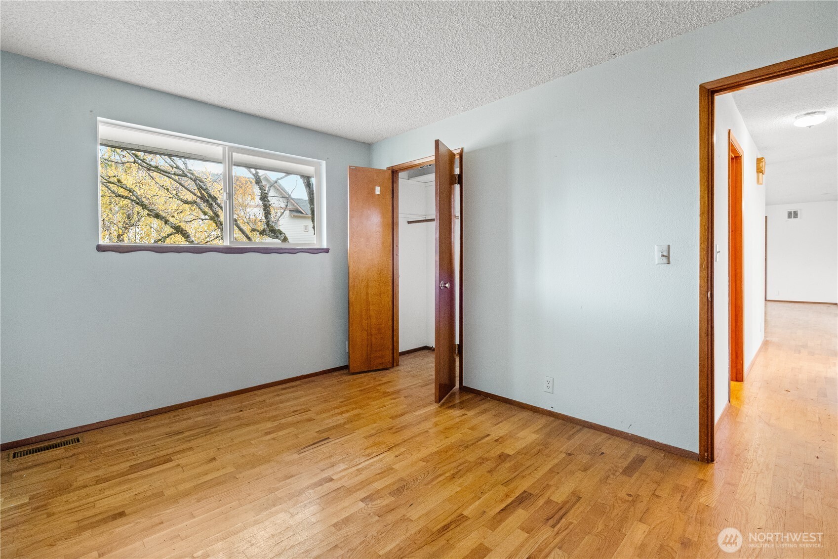 9139 Burnett Road Southeast Yelm, WA 98597 - Photo 17 of 40 a view of an empty room with wooden floor and a window