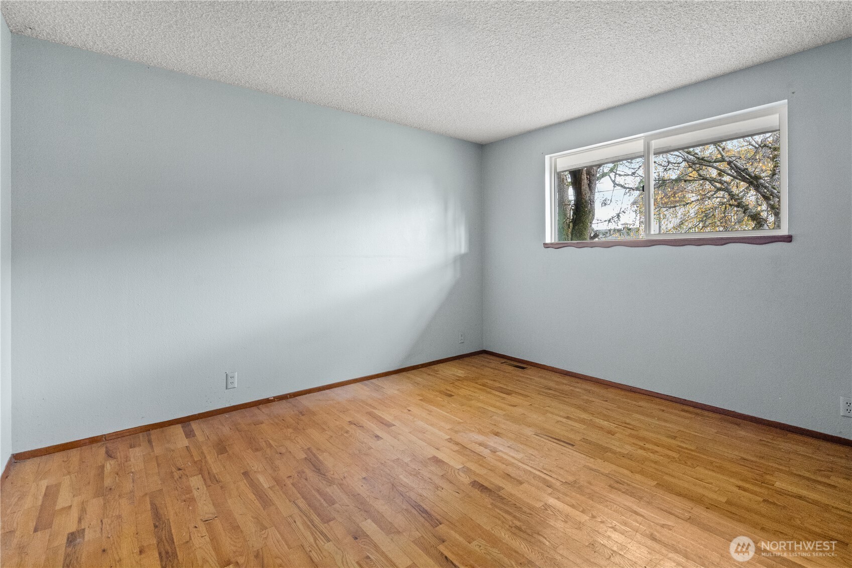 9139 Burnett Road Southeast Yelm, WA 98597 - Photo 18 of 40 a view of an empty room with wooden floor and a window