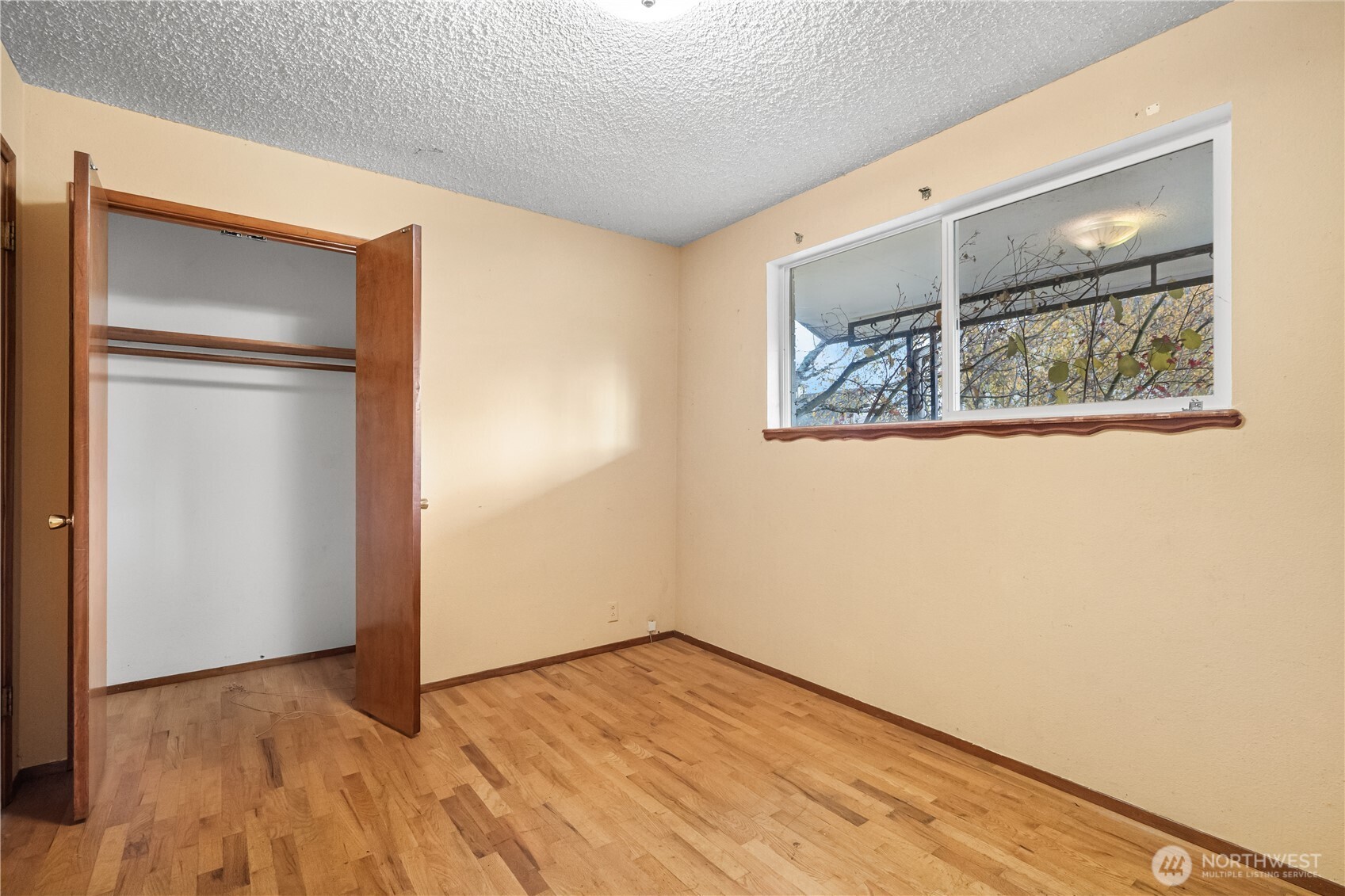 9139 Burnett Road Southeast Yelm, WA 98597 - Photo 21 of 40 a view of an empty room with wooden floor and a window