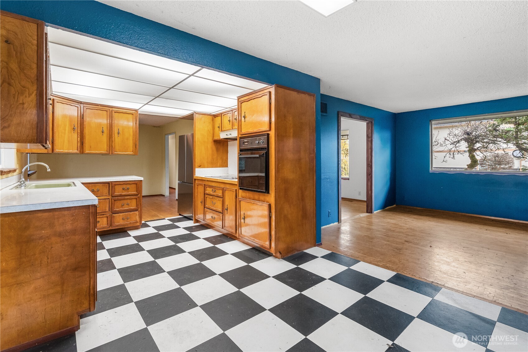 9139 Burnett Road Southeast Yelm, WA 98597 - Photo 10 of 40 a room with a black white checkered floor with a gaming machine and dining chairs
