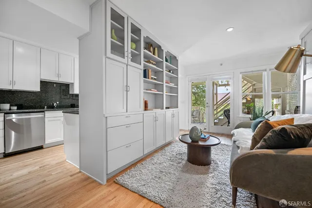 a kitchen with stainless steel appliances granite countertop a dining table chairs and a microwave