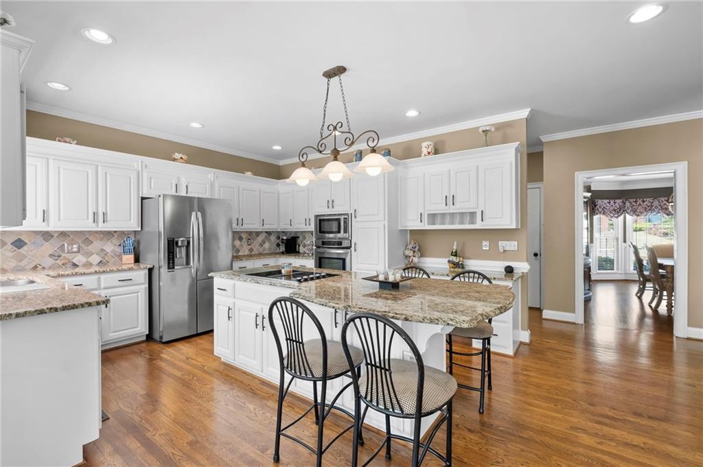 5870 Brookstone Walk Northwest Acworth, GA 30101 - Photo 15 of 79 a kitchen with stainless steel appliances granite countertop a dining table chairs refrigerator and microwave