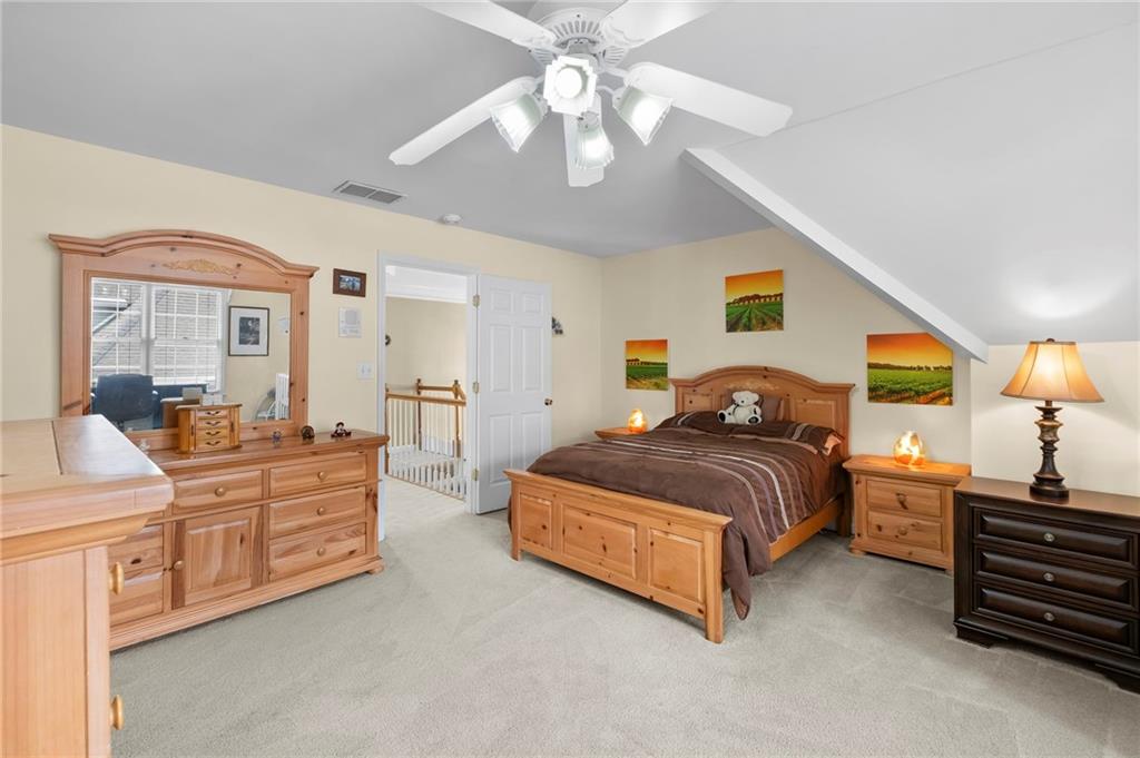 5870 Brookstone Walk Northwest Acworth, GA 30101 - Photo 27 of 79 a spacious bedroom with a bed and a chandelier
