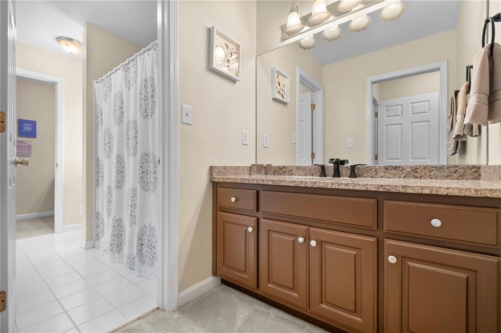 5870 Brookstone Walk Northwest Acworth, GA 30101 - Photo 33 of 79 a bathroom with a granite countertop sink and a mirror