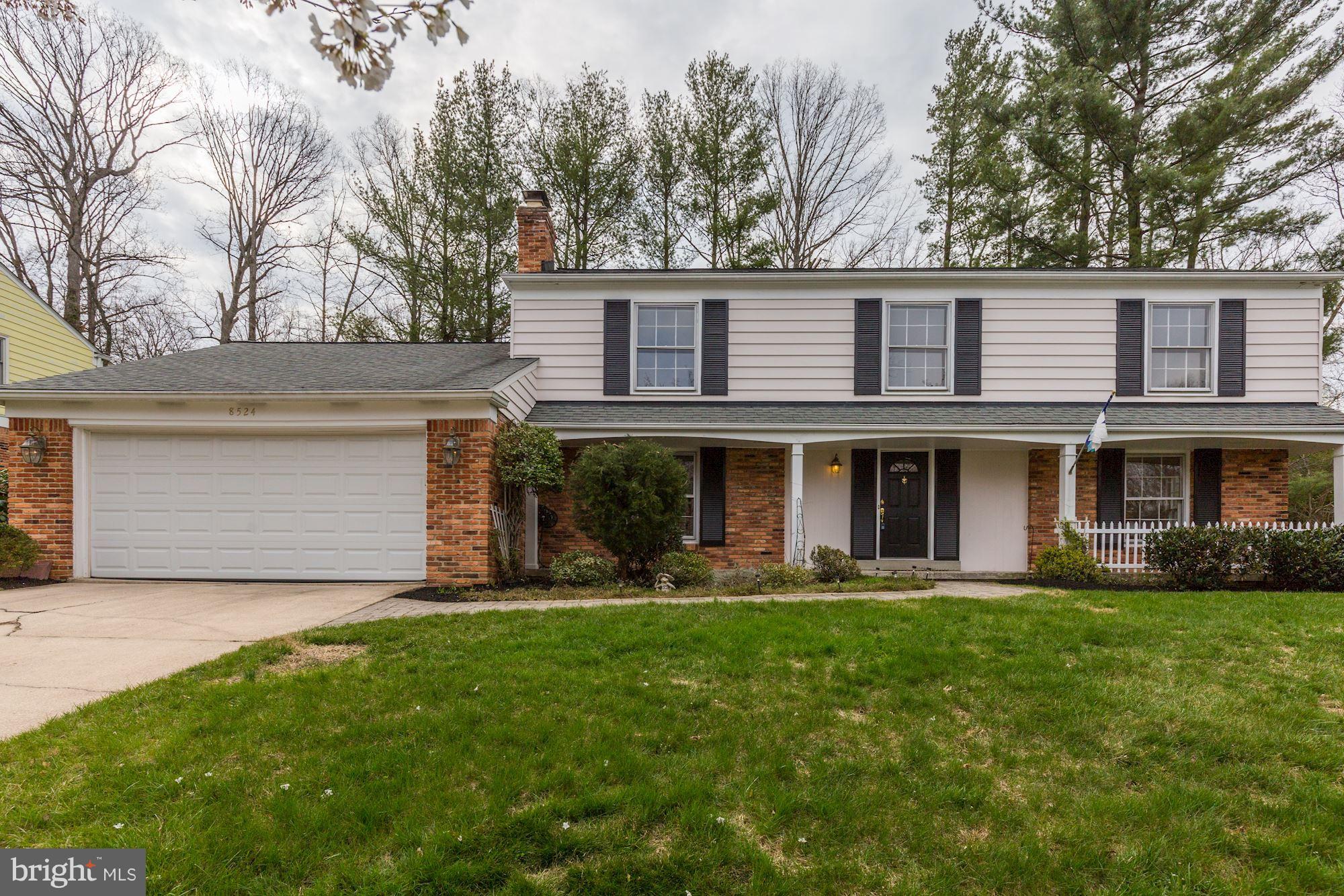 a front view of a house with a yard and trees