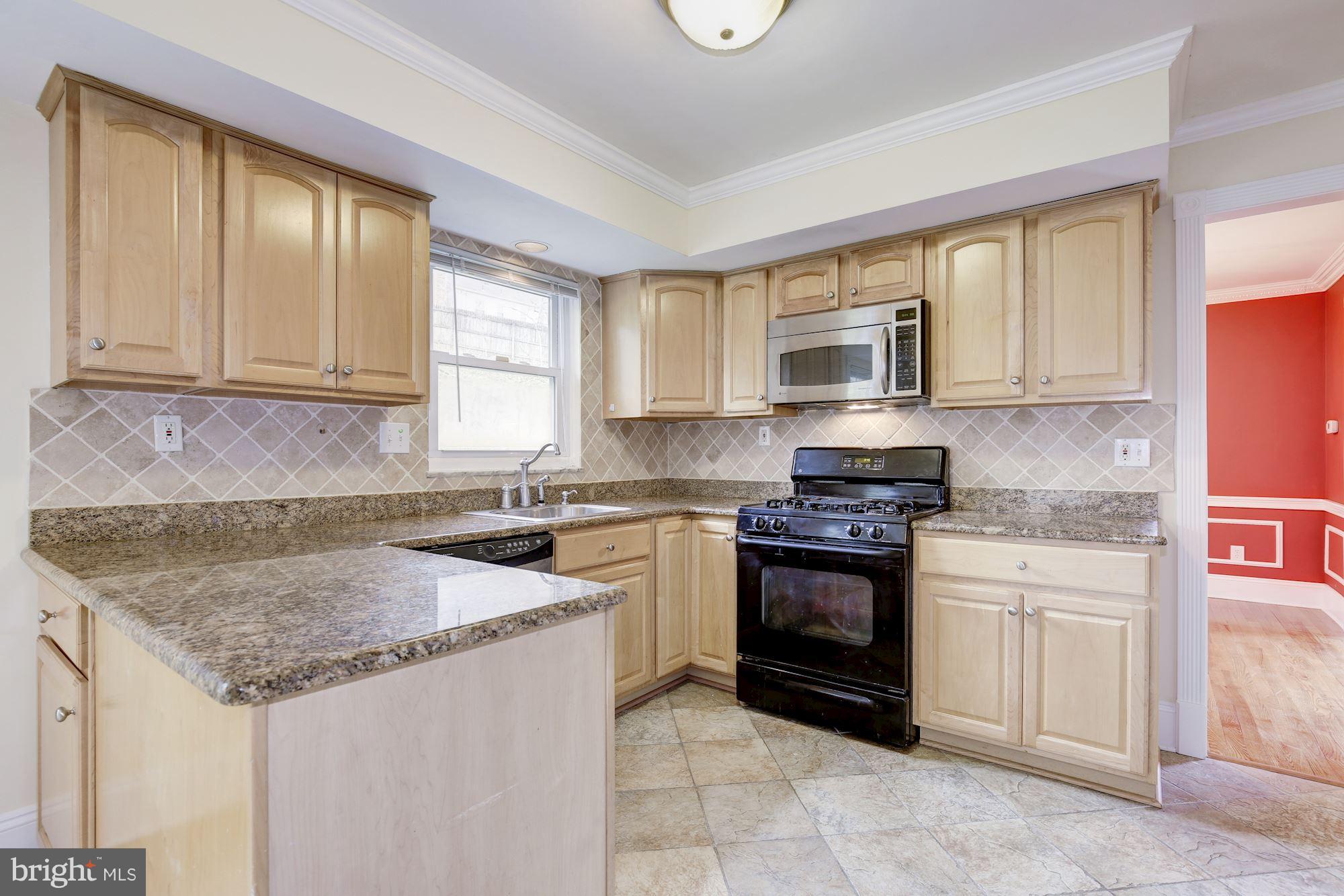 8524 Fox Run Potomac, MD 20854 - Photo 13 of 30 a kitchen with granite countertop a sink stove and microwave