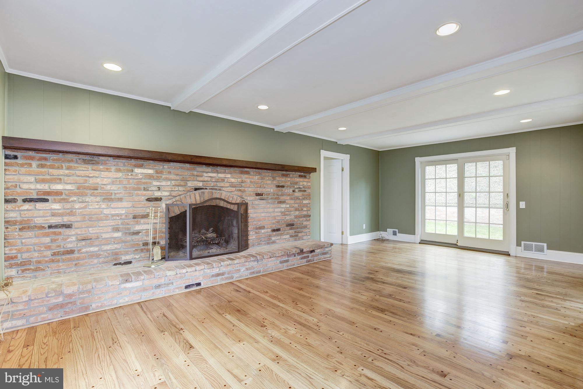 8524 Fox Run Potomac, MD 20854 - Photo 6 of 30 an empty room with wooden floor a fireplace and windows